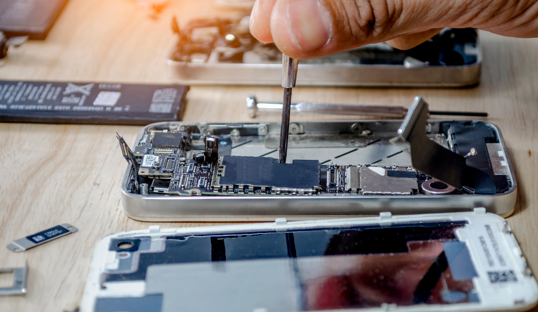 disassembled iphone on workbench being repaired by smartphone repair tech