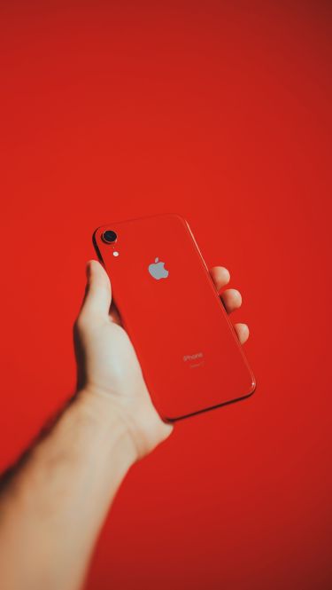 hand holding a red refurbished replacement phone